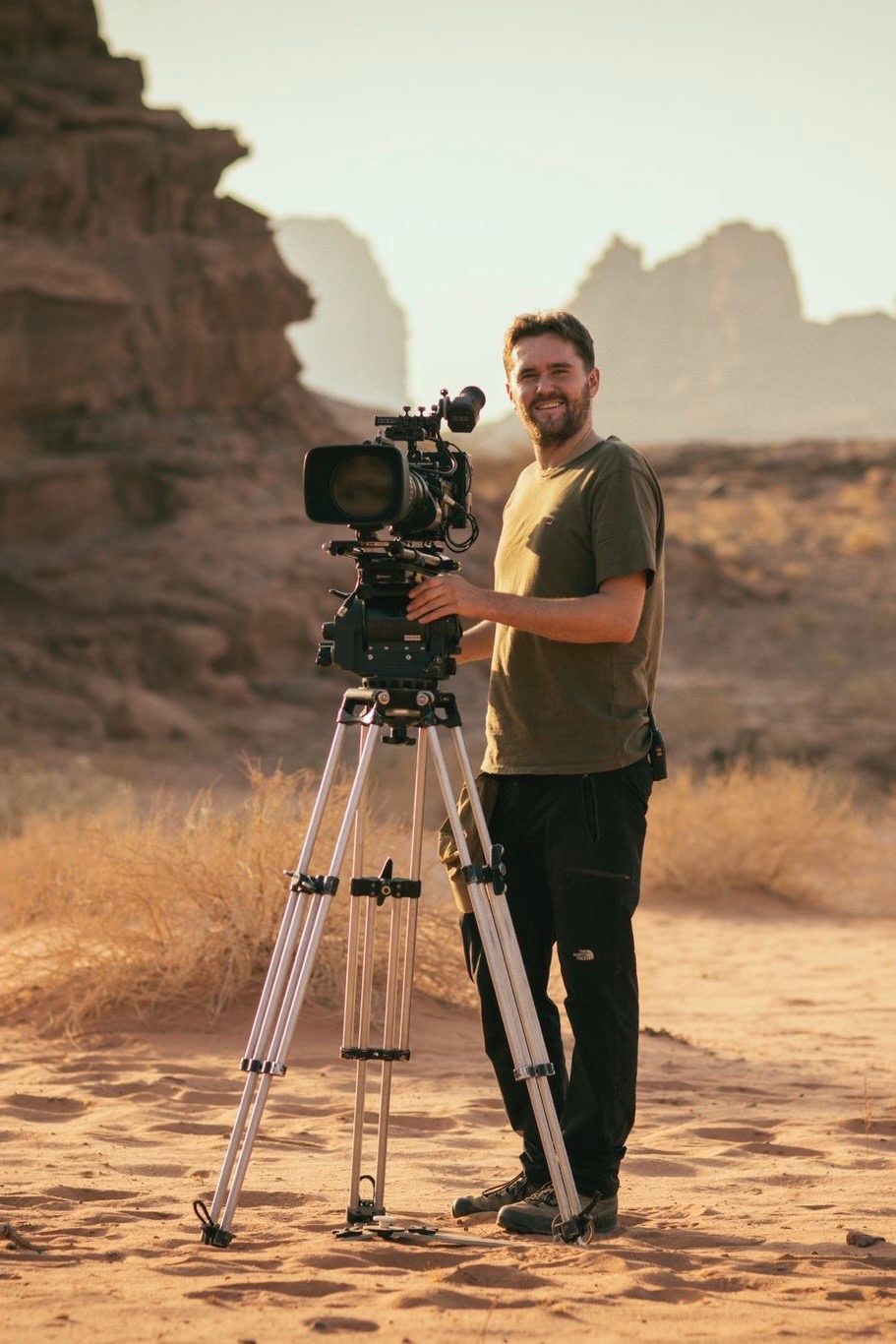 Christian Marot, wildlife cinematographer, with a cinema camera on a tripod in the desert